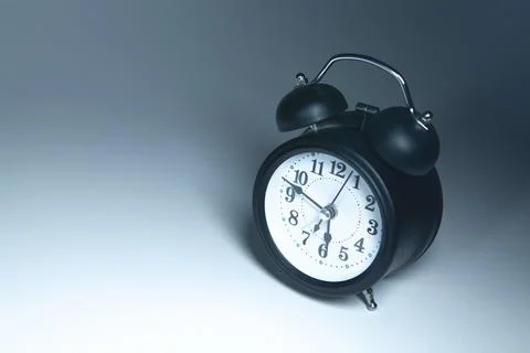 Black alarm clock on a gray background. Copy space for text. Stock Photos