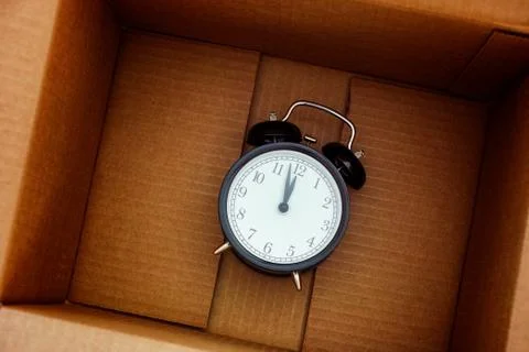 Black alarm clock inside a box Stock Photos