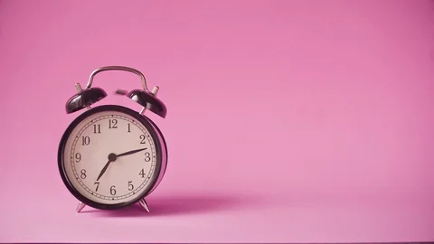 Black alarm clock on a pink background. Copy space Stock Footage 129324996