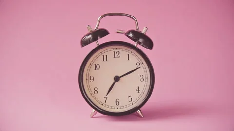 Black alarm clock on a pink background. Stock Footage 132358242