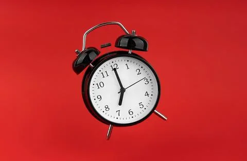 Black alarm clock on a red background. 스톡 사진