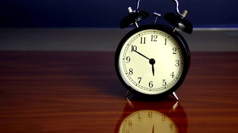 Black alarm clock running timelapse time passing on isolated desk wood back.. Stock Footage 272761057