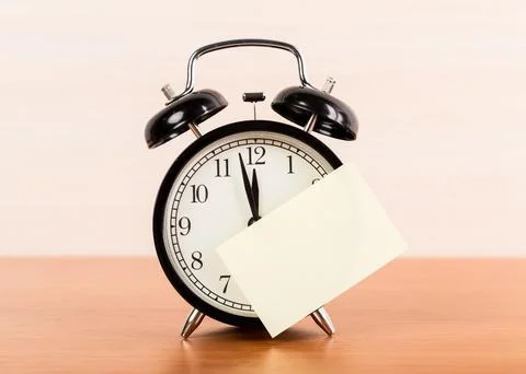 Black alarm clock on the table. Twelve oclock Stockfoto's