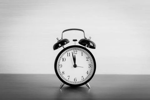 Black alarm clock on the table. Twelve oclock Stockfoto's