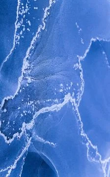 Black alcohol ink forms abstract shapes and patterns on a canvas Stock Photos