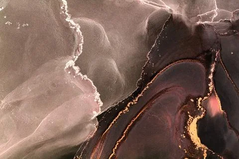 Black alcohol ink forms abstract shapes and patterns on a canvas Stock Photos