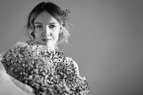Black amd white studio portrait of young beautiful woman with bunch of purple Stock Photos