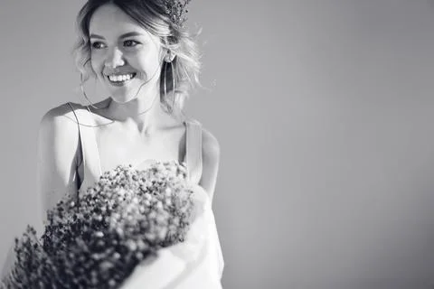 Black amd white studio portrait of young beautiful woman with bunch of purple Stock Photos