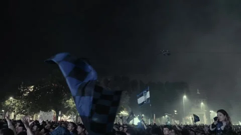 Black and blue checkered flag waving above the Atalanta supporters crowd Stock Footage 276179454
