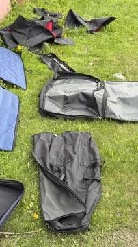 Black and blue soft protective cases for gear scattered on green lawn with Stock Photos