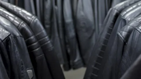 Black and brown leather jackets on a hanger in a store Video stock 271025305