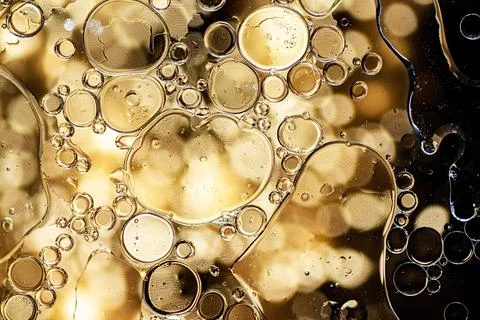 Black and gold abstract pattern made with oil bubbles on water Stock Photos