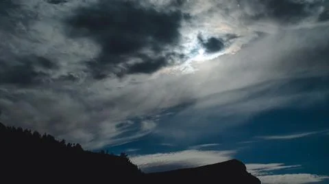 Black and gray clouds against a full moon and stars. Black silhouette of the  Stock Photos
