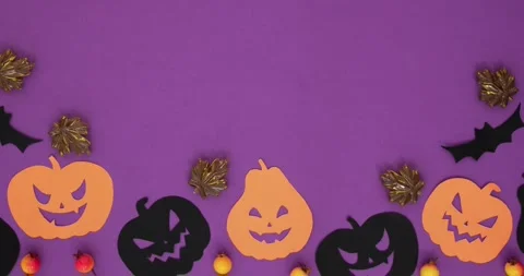 Black and orange pumpkins, bats, leaves and "Happy Halloween" text on an purple Stock Footage 345632262