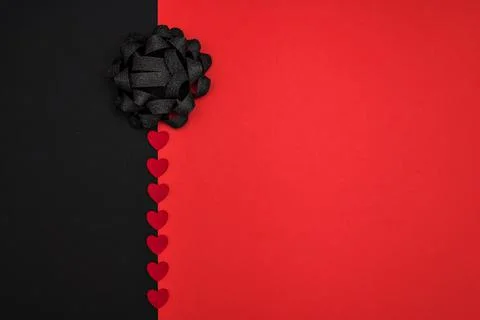 Black and red background decorated with a black bow and red hearts, Foto stock