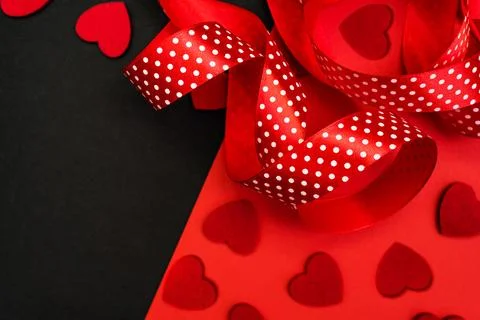 Black and red background with red ribbon and hearts. Stock Photos