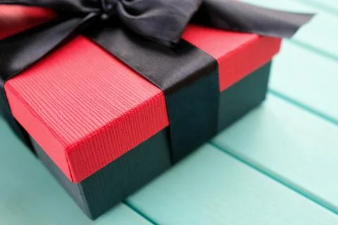 Black and red box with a bow on a blue background Stock Photos