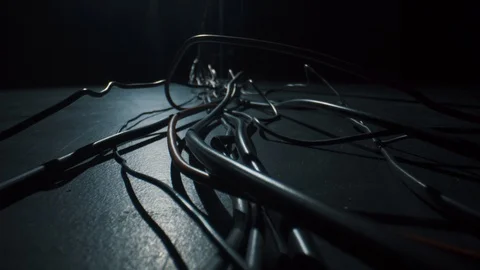 Black and red cables lie on the floor, macro on Laowa 24mm f / 14 Macro. 4k Stock Footage 125930995