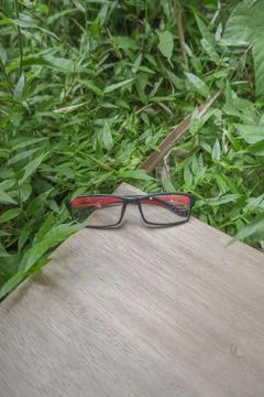 Black and red combination square eyeglass frames on old wood. square eyeglass Stock Photos