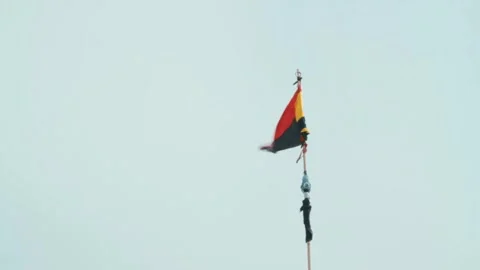 Black and red danger flag waving on a stick with gray sky in the background Stock Footage 264225164