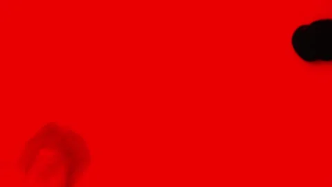 Black and red paint is mixed on a red background. Stock Footage 276907016