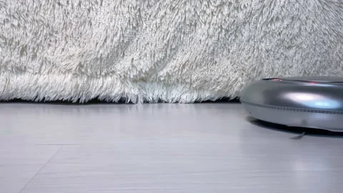Black and silver robotic vacuum cleaner on  floor. Stock Footage 156250183