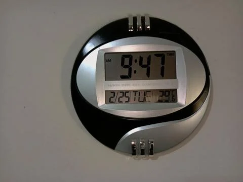 Black and silver round digital clock on a wall. Stock Photos
