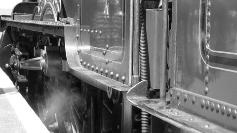 Black and white 4K shot of engine driver climbing onto steam train Stock Footage 77420188