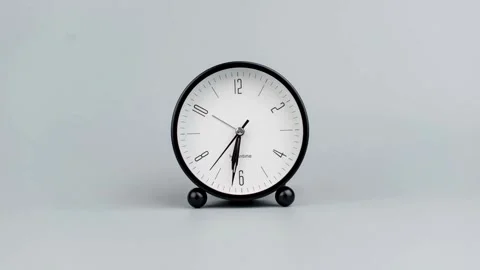 Black and white alarm clock ticking on a grey background Stock Footage 336397349