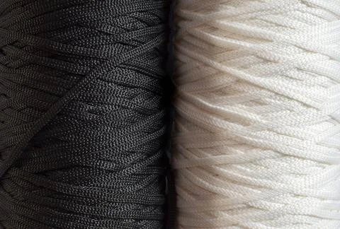 Black and white background with two big bobbins of polyester cord, concept of Stock Photos