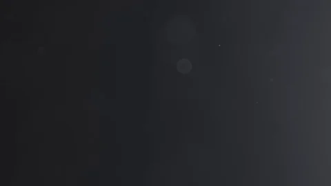 Black and white backlit dust particles with bubble like bokeh floating in slow Stock Footage 70187652