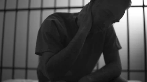 Black and white Backlit scene of a despondent inmate in prison Stock Footage 60574306
