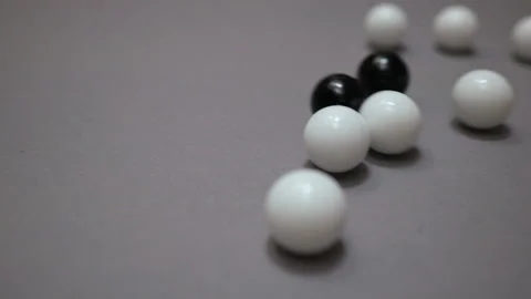 Black and white balls rolling and colliding chaotic on gray suface Stock Footage 147107658