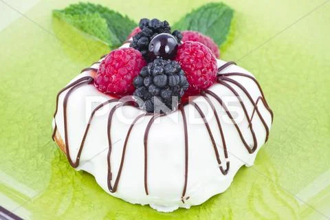 Black and white chocolate with blackberries on green plate Stock Photos