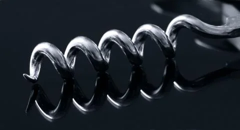 Black and white close-up of a corkscrew on a mirrored surface Stock Photos