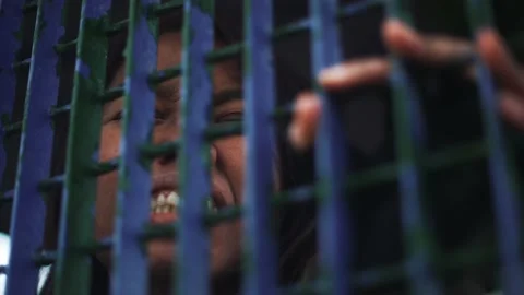 Black and white Close up of a hand sticking out from the jail's cell bars Stock Footage 171564891
