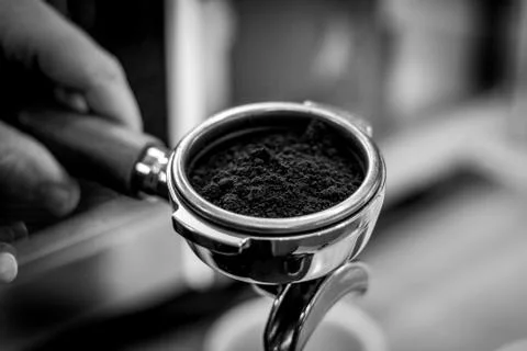 A black and white close up portrait of a portafilter full of coffee grounds f Foto stock