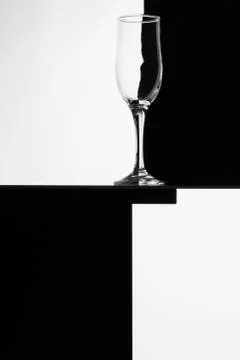 Black and white composition with empty wineglass on a table. Stock Photos