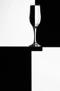 Black and white composition with empty wineglass on a table. Stock Photos
