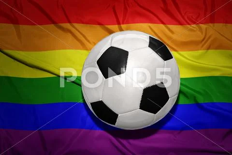 Black and white football ball on the rainbow gay flag Stock Photos