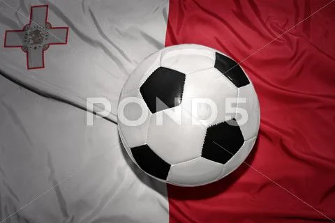Black and white football ball on the national flag of malta Stock Photos