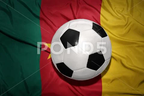 Black and white football ball on the national flag of cameroon Stock Photos