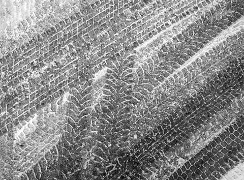 Black and white grunge vector background with texture of tire tracks Stock Illustration