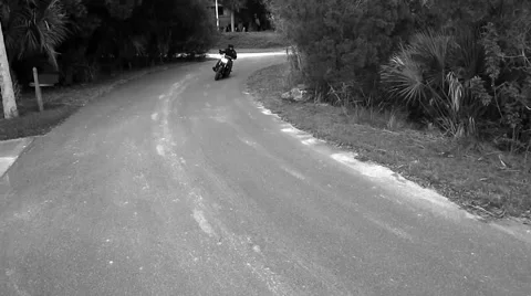 Black and white high shot of motorcycle coming around corner Stock Footage 45289738
