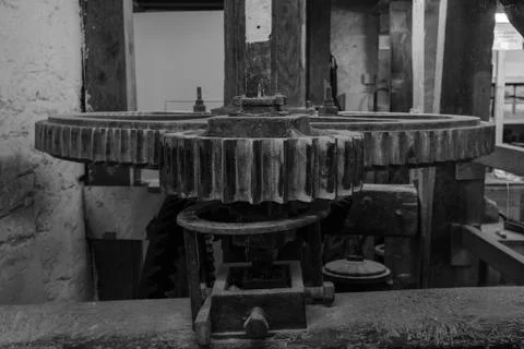 A black and white image of the cogs inside a watermill in Devon, England, taken Stock Photos