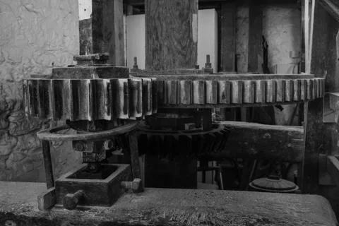 A black and white image of the cogs inside a watermill in Devon, England, taken Stock Photos