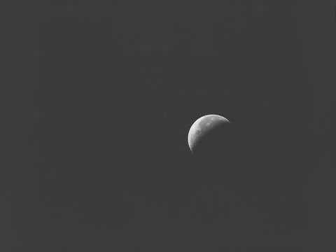 Black and white image of a crescent moon shines in the sky Stock Photos