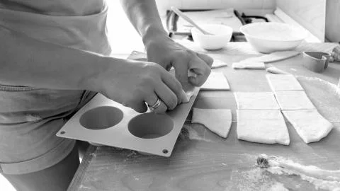Black and white image of young woman making cupcakes in silicone form on kitchen Stock Photos