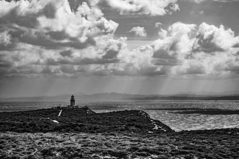 Black and white lighthouse at dramatic coast Stock-Fotos