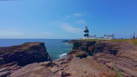 Black and white lighthouse on rocky cliff against ocean Stock Footage 340451038